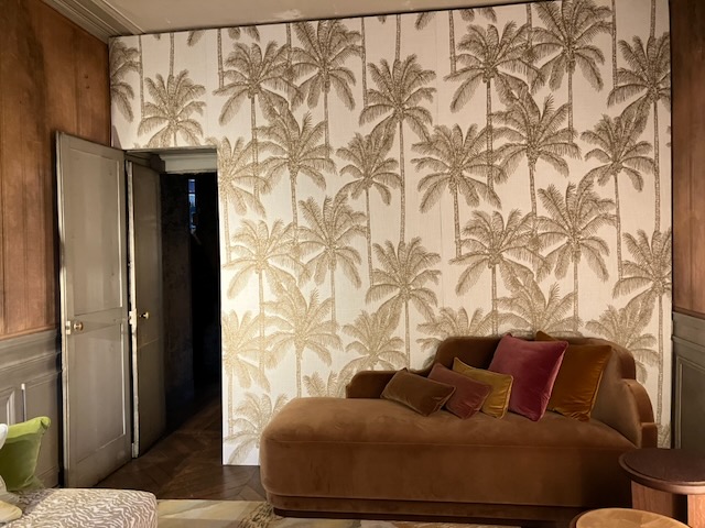 Papier peint à palmiers dans un salon, canapé de velours
